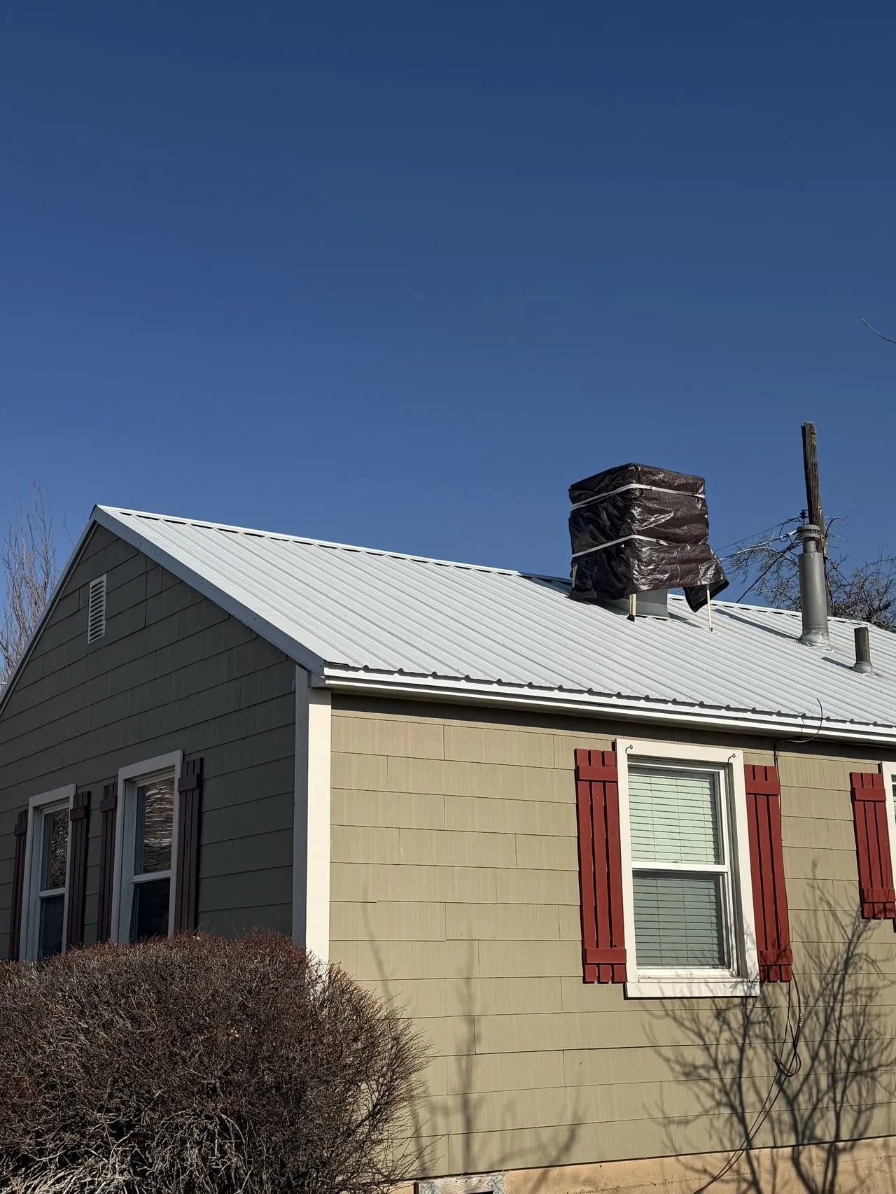 Frame Restoration Utah technician performing a spring rooftop inspection on a Utah residence - looking for winter damage and sealant failures