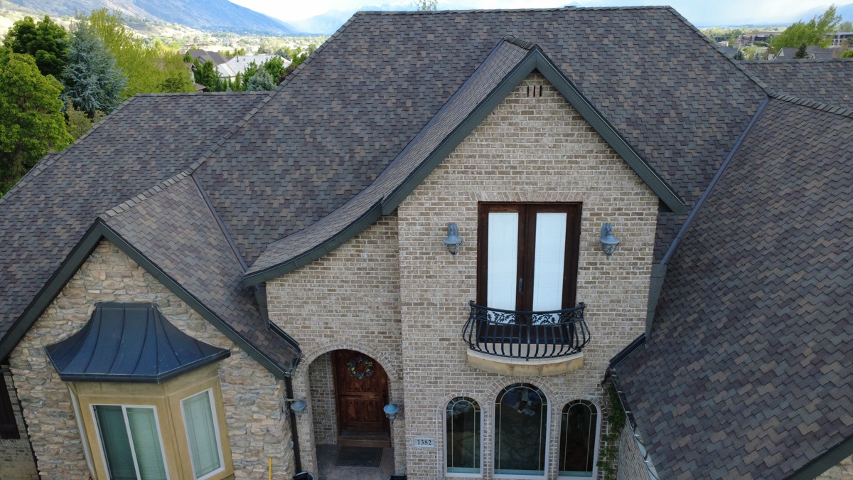 Aerial of a stone and brick custom luxury home reroofed by Frame Restoration Utah, Wasatch foothills, May 2026